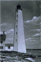 Black and white image of the New London Harbor lighthouse, the keeper’s house, and the rocky coastline.