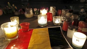 Candles are pictured around a Belgian flag on the Place de la Republique in Paris, France following bomb attacks in Brussels, Belgium, March 22, 2016. REUTERS/Philippe Wojazer - RTSBRZ3