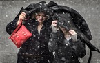 Jodi Walker-Robinson and daughter Tori tried to fight off the fat wet snowflakes in River Falls, Wis. on Wednesday.