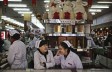 Chinese clerks chat as they wait for customers at a market in Beijing on Jan. 19, 2016.  (Kevin Frayer/Getty Images)