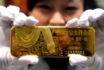 A woman holds a gold bar to mark the year of the snake in Beijing in 2012.  (STR/AFP/Getty Images)