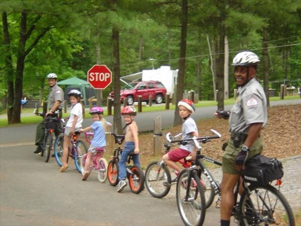 Kids riding bikes with Park Rangers.
