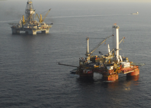 GULF OF MEXICO - Rigs drilling a relief well and preparing the static kill are seen over the Deepwater Horizon well about 40 miles from the Southern Louisiana coast July 31, 2010. An additional rig is drilling a second relief well but is not pictured. U.S. Coast Guard photo by Petty Officer 1st Class Sara Francis. 