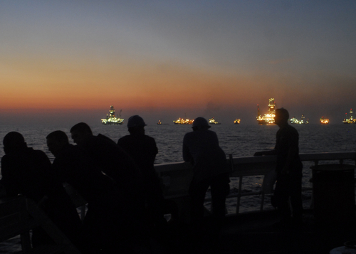 GULF OF MEXICO - Crewmembers aboard the 210-foot Coast Guard Cutter Decisive observe the lights from the drilling rigs and support ships near the sight of the Deepwater Horizon well about two miles away July 31, 2010. The Decisive is being utilized as a safety platform for the increased traffic in the area of the well site. U.S. Coast Guard photo by Petty Officer 1st Class Sara Francis. 