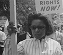 Black woman holding a placard in a civil rights march