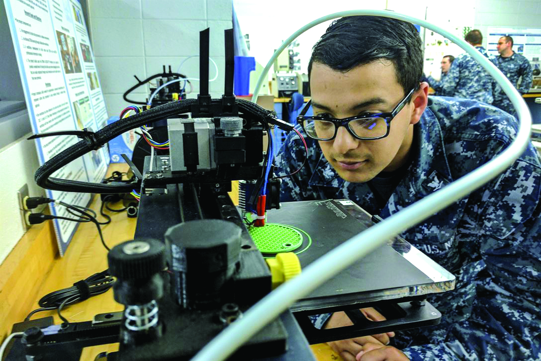 Source: U.S. Navy, A Navy sailor examines a 3D printer during a course at Old Dominion University in Virginia.