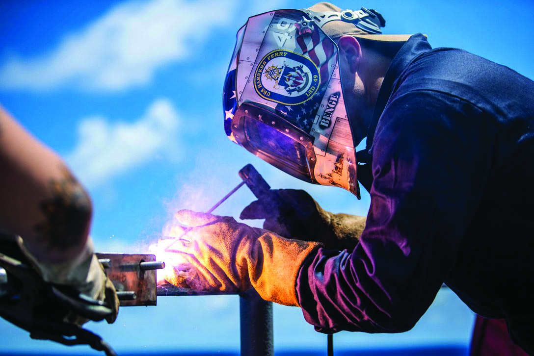 Source: DoD, A Navy sailor welds on the USS Harpers Ferry.