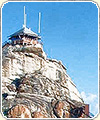 Photograph of a lookout tower on a tall, rocky hill.