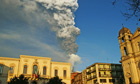 Smoke and ash billow from Mount Etna framed by the Sicilian town of Zafferana