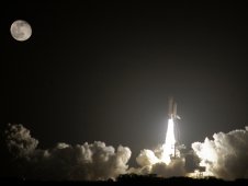 Image of space shuttle night launch in light of the full moon