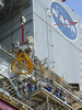 Stennis Space Center engineers and technicians watch as the J-2X powerpack is hoisted into place on the A-1 Test Stand.