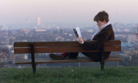 A woman reading a self-help book on Hampstead Heath