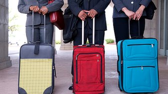Business people standing with suitcases - Thinkstock image
