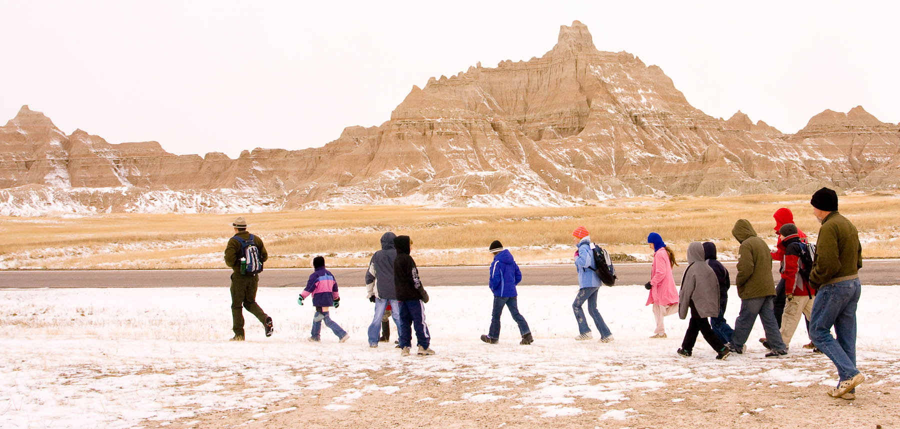 A park ranger leads a group of students across the prairie. 