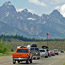 Cars approaching Moose Entrance with Tetons in background