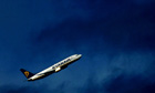 A Ryanair aircraft flying into a darkened sky