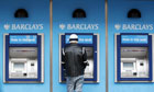 A man uses a cashpoint machine at a Barc
