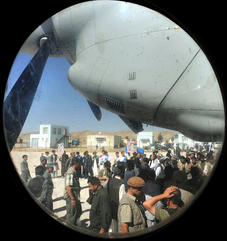 A group of supporters gather on the tarmac to greet Afghan presidential candidate Abdullah Abdullah in Maymana, Afghanistan.