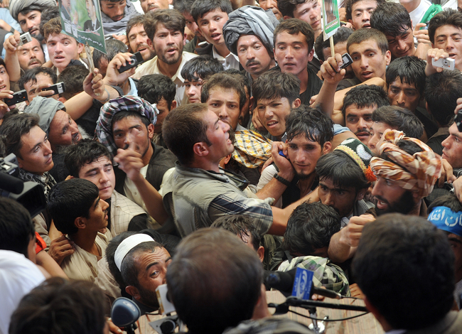 A member of Abdullah Abdullah's security detail tries to subdue a rush of supporters, vying to get a position in front of the stage at a rally in Maymana, Afghanistan.