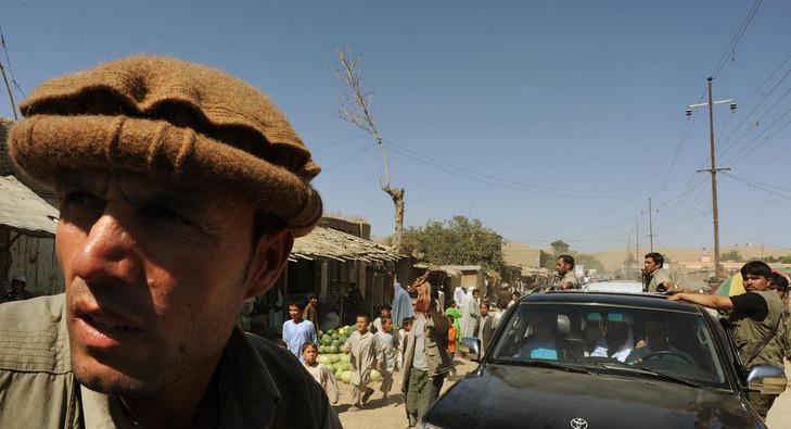 A member of Abdullah Abdullah's security detail watches the crowd for danger after a rally in Maymana, Afghanistan.