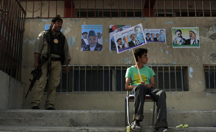 An Afghan boy waits for the arrival of President Hamid Karzai at the National Stadium in Kabul, Afghanistan.