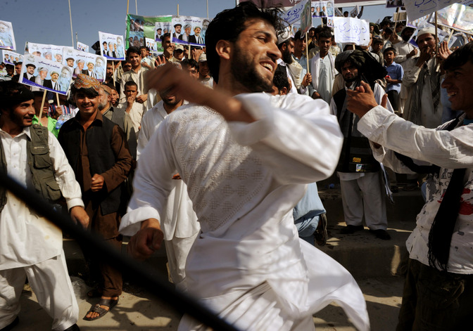 An supporter of President Hamid Karzai dances during a rally for at the National Stadium in Kabul.