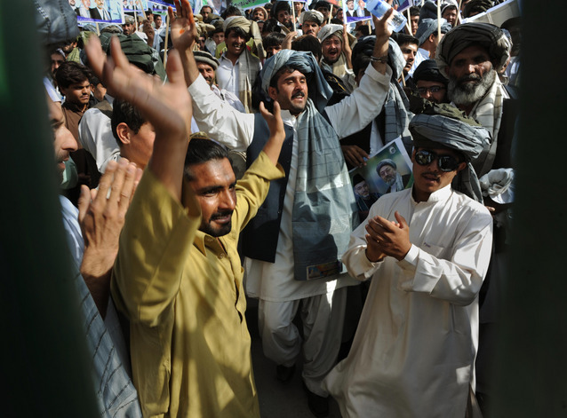 Afghan men dance before the the arrival of Afghan President Hamid Karzai for a rally at the National Stadium in Kabul. The event was held in close proximity to the site where an assassination attempt was made on Karzai's life two years ago.