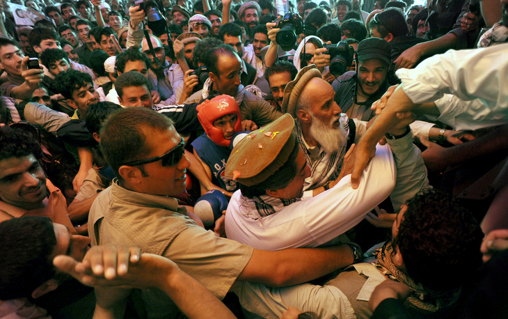 Afghan presidential candidate Dr. Abdullah Abdullah, surrounded by supporters, is helped onto the stage during a rally in Istalif, Afghanistan.