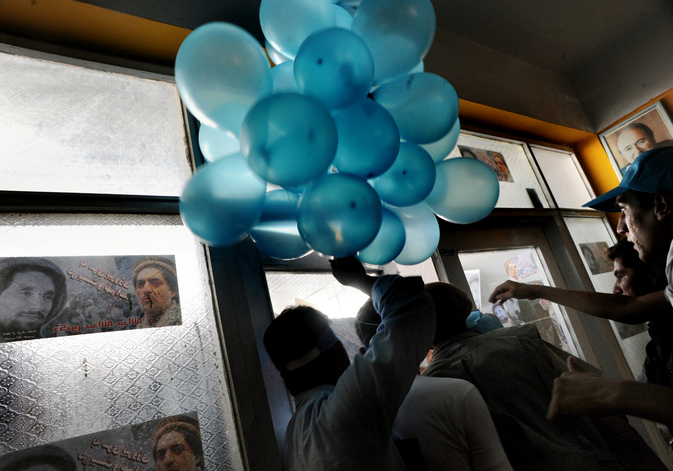 A supporter of Afghan presidential candidate Abdullah Abdullah carries balloons into a rally at Kabul's National Stadium.