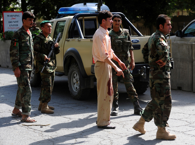 A man in blood-soaked clothing stands near the site of a suicide car-bombing outside NATO headquarters in Kabul. The blast, which killed seven and injured 91 Afghans, comes five days before the scheduled Aug. 20 elections, and is the most serious indication yet of the Taliban's designs to disrupt the election through violence.