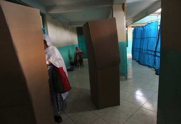 An Afghan woman prepares to cast her vote at a local mosque in Kabul. President Hamid Karzai was expected to win a plurality over three major rivals, leading to a second round of voting that he was also likely to win. 
