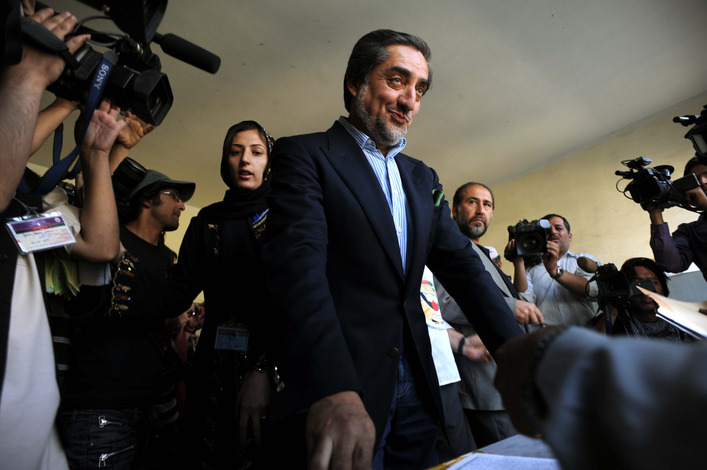 Afghan presidential candidate Abdullah Abdullah, President Hamid Karzai's main rival, prepares to cast his vote surrounded by the crush of media at a local high school in Kabul.