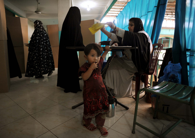 Afghan women prepare to cast their vote at a local mosque in Kabul. Taliban insurgents had been widely expected to try to attack polling places and voters. Leaders of the Islamist movement had threatened to kill or main anyone they caught who had voted.