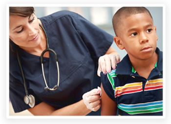 A nurse cleans the arm of a small boy