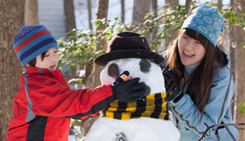 Photo of two kids building a snowman