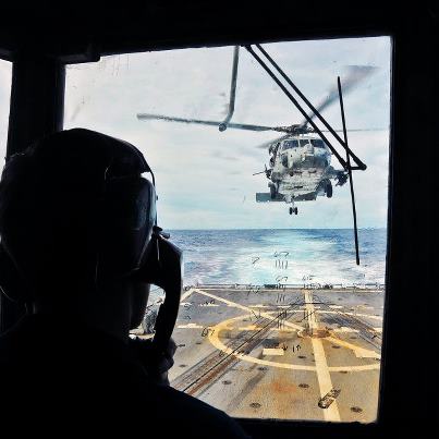 Photo: Photo of the Day: U.S. Navy Lt. j.g. Thad Brill provides guidance to a helicopter pilot during flight operations aboard the guided-missile destroyer USS McCampbell under way in the Pacific Ocean, Sept. 1, 2012. The McCampbell is part of the George Washington Carrier Strike Group and is conducting a routine western Pacific patrol. U.S. Navy photo by Seaman Declan Barnes