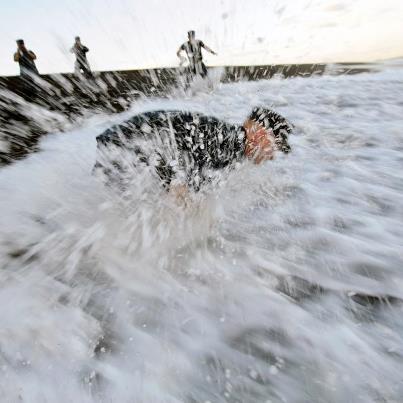 Photo: Photo of the Day: U.S. Navy Chief Petty Officer Andrew Thomasson is splashed by water as he fulfills his promise and lays his grandfather's ashes to rest on Iwo Jima's Invasion Beach in Iwo Jima, Japan, Aug. 28, 2012. His grandfather, Petty Officer 2nd Class Oscar Thomasson, survived the battle even though his landing craft was destroyed en route to the island. Thomasson, 80, died Dec. 22, 2006. U.S. Navy photo by Senior Chief Petty Officer Daniel Sanford