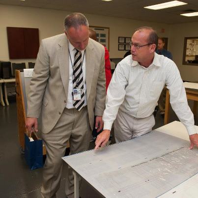 Photo: Prepress Foreperson Milton Conley shows OFR Director Charley Barth a plate in the prepress section.