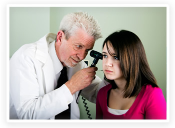 A primary care physician examines the ears of a teenage girl