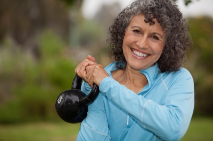 middle-aged woman holding a kettle bell weight