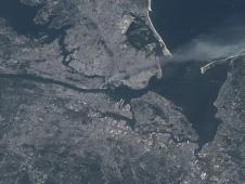 Visible from space, a smoke plume rises from the Manhattan area after two planes crashed into the towers of the World Trade Center. This photo was taken of metropolitan New York City (and other parts of New York as well as New Jersey) the morning of September 11, 2001. 