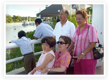 A disabled woman enjoys a summer day with her parents and daughter