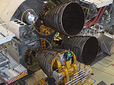 A technician guides replica shuttle main engine 2 toward space shuttle Endeavour