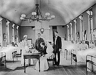 1916 photograph of Dr. Joseph Goldberger seated at a table in a hospital surrounded by four assistants