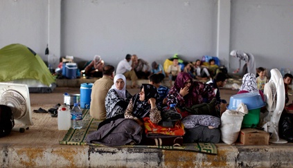 Syrians take refuge at the Bab Al-Salameh border crossing near the Syrian town of Azaz / AP Image