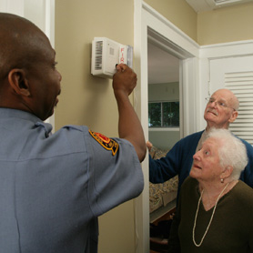 foto de una mujer de instalar una alarma de humo