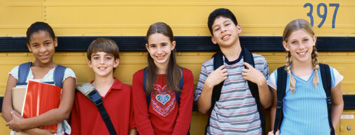 Photo: 6 elementary school children laughing in front of chalkboard