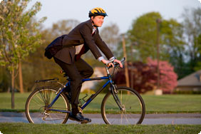 A Man in a Suit Riding a Bike