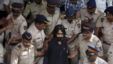 Indian policemen escort political cartoonist Aseem Trivedi, center in black as they leave a court in Mumbai, India, Monday, Sept. 10, 2012.