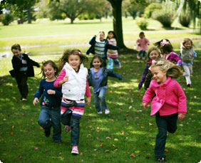 Group of diverse kids running outside in fall
